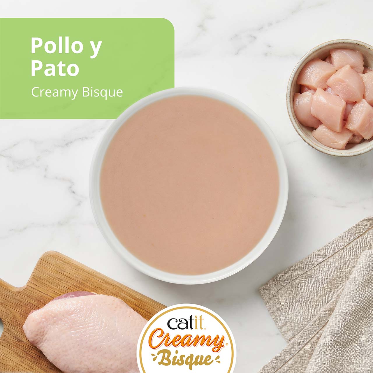 Snack para gatos Catit Creamy Bisque con sabor a pollo y pato, acompañado por un plato de pollo crudo y pechuga de pato
