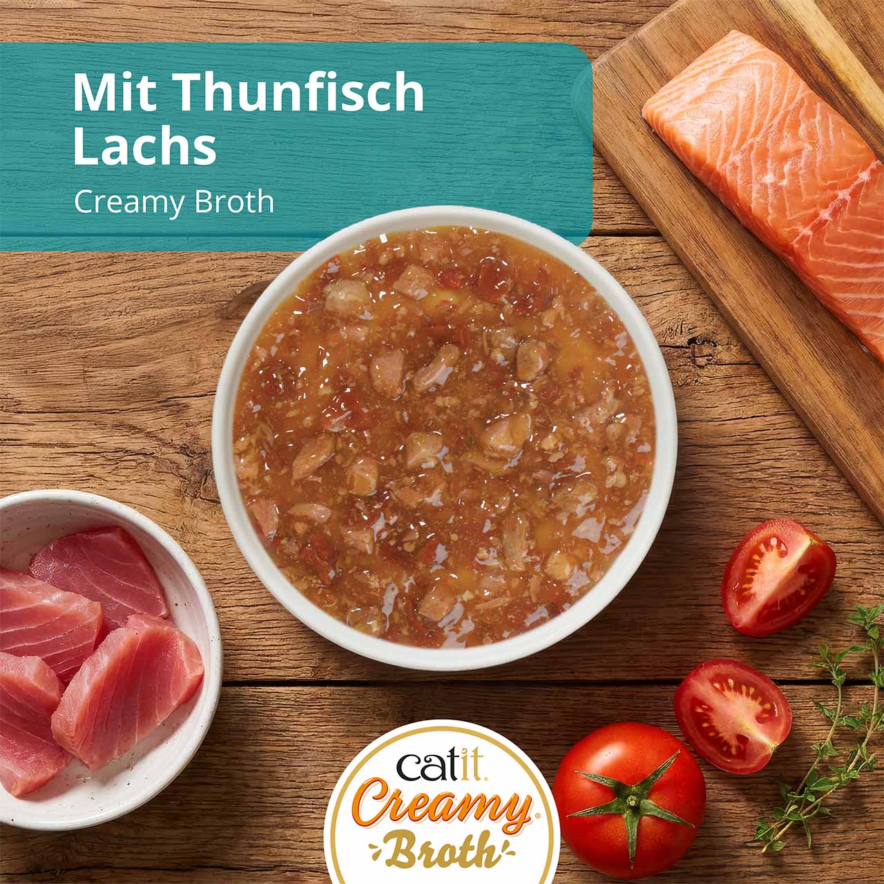 Catit Creamy Broth mit Hühnerfleisch und Entenfleisch auf einer Küchenarbeitsplatte aus Holz