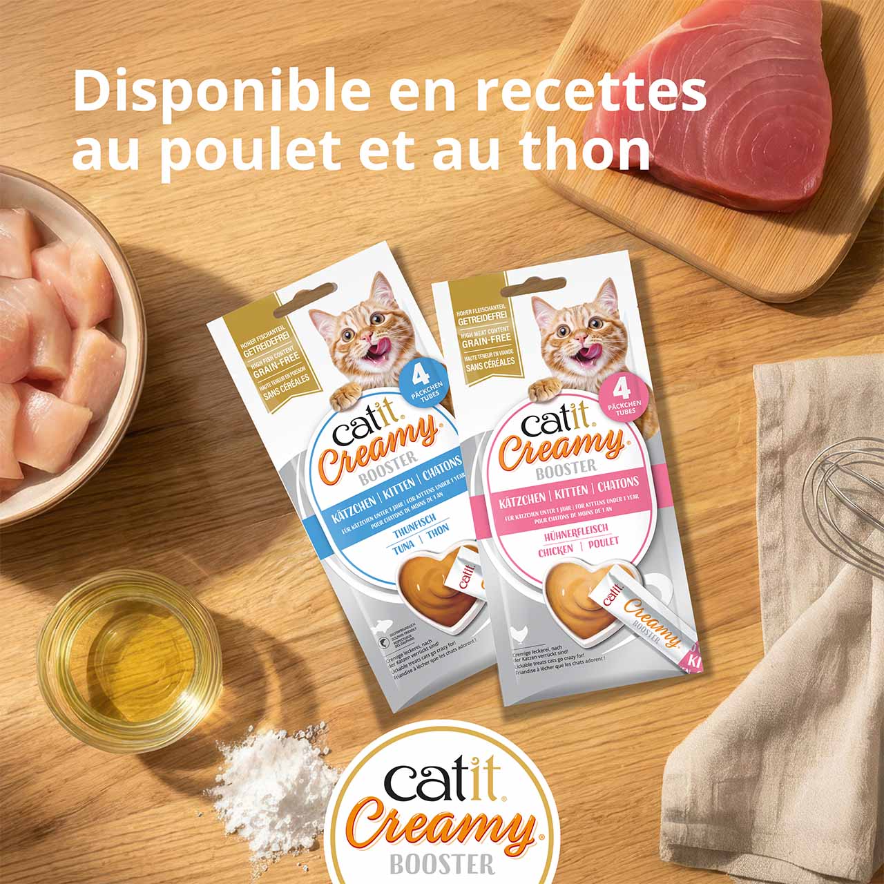 Emballages de Catit Creamy Booster Chatons posés sur un plan de travail en bois, avec les ingrédients disposés autour, vue de dessus